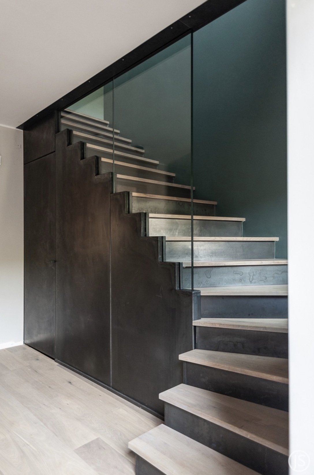 Hausflur Treppe aus Schwarzstahl mit Eiche Massivholz Treppenstufen geölt und Glasscheibe als Brüstung